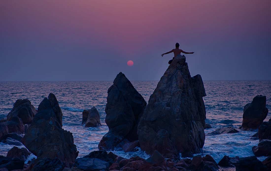 Yogi on the rock at Arambol Beach, Goa